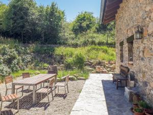 eine Terrasse mit einem Holztisch und Stühlen in der Unterkunft Albergue A'Noguera in Castiello de Jaca