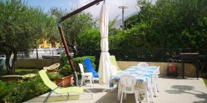 a patio with a table and chairs and an umbrella at Hawaii Siciliane in Castelluzzo