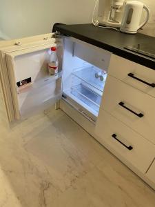 an empty refrigerator with its door open in a kitchen at ApartPark Albus1 in Świnoujście