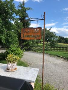 a sign for a garden cafe with a table at Pension Sigle in Dingolfing