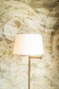 a lamp in front of a stone wall at Hotel Villa Pascucci in Durrës