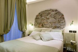 a bedroom with a large bed with a stone wall at Hotel Marina in Monterosso al Mare