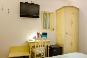 a bedroom with a desk and a tv on the wall at Hotel Marina in Monterosso al Mare