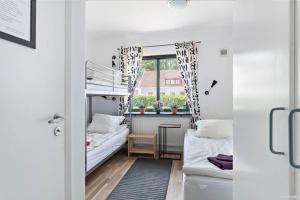 a small room with two bunk beds and a window at Bruksparkens Hostel in Vellinge