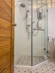 baño con cabina de ducha con puerta de cristal en บ้านในกาด-ที่พักน่าน โรงแรมน่าน เที่ยวน่าน en Nan