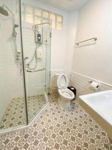 a bathroom with a shower and a toilet and a sink at บ้านในกาด-ที่พักน่าน โรงแรมน่าน เที่ยวน่าน in Nan