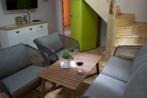 a living room with two chairs and a table with a glass of wine at Hiška ob potoku in Dobrna
