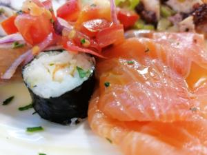 a plate of sushi with salmon and other vegetables at Hotel Astor in Rimini