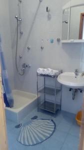 uma casa de banho com um chuveiro e um lavatório. em Apartments Keti em Pag