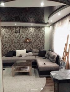 a living room with a couch and a table at Здається подобово 3кімнатна квартира з wifi i екслюзивним ремонтом,є кімната гардероб,спальня і кімната,санвузол і ванна також парковочне місце in Chernivtsi