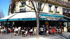 un grupo de personas sentadas fuera de un restaurante en Trendy and Chic in the heart of Saint-Germain des Prés, en París