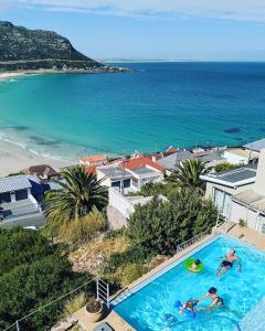 two people in a swimming pool next to a beach at Above the Sea in Fish hoek