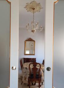 a dining room with a table and a chandelier at Spa sul tempio d'apollo in Syracuse