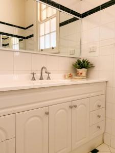 bagno bianco con lavandino e specchio di The Coorow Hotel a Coorow