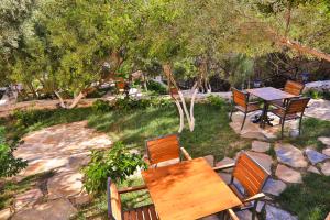einen Holztisch und Stühle in einem Garten mit Bäumen in der Unterkunft Atalante Hotel in Kaş