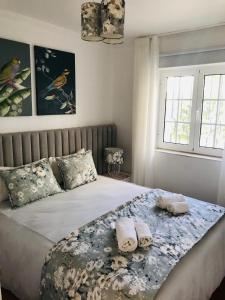 um quarto com uma cama com duas toalhas enroladas em Old Village em Vilamoura