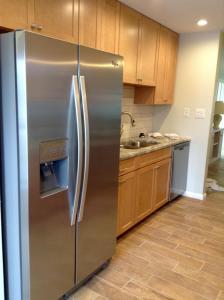 a stainless steel refrigerator in a kitchen with wooden cabinets at Island House Beach Resort 4S in Point O'Rocks