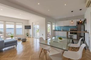 a kitchen and living room with a glass table and chairs at Apartment Shades of Blue in Hvar