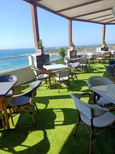 a patio with tables and chairs and the ocean at Jewel Mandara Apartments in Alexandria