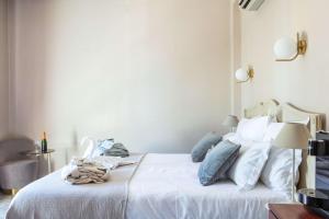 a bedroom with a bed with white sheets and blue pillows at Hôtel Le Maxime - Best Western Signature Collection in Auxerre