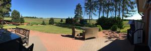 eine Terrasse mit Stühlen, einem Tisch und einem Feld in der Unterkunft Privatquartier 73 in Wietzen