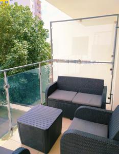 einen Balkon mit 2 Stühlen, einem Tisch und einem Sofa in der Unterkunft Apartament Niebieski in Świnoujście