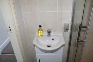 y baño con lavabo blanco y ducha. en The Bay House Lake View Guest House - Adults Only, en Bowness-on-Windermere