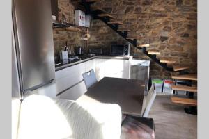 - une cuisine avec des placards blancs et un mur en pierre dans l'établissement El Apartamentín de Verdiago, à Verdiago