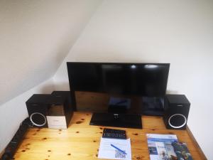 a computer monitor and speakers on a wooden desk at Ferienwohnungen und Ferienhaus im Nixenweg in Hohwacht