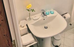 - un lavabo blanc dans la salle de bains pourvue d'un vase avec une fleur dans l'établissement Clos Monicord, à Vérac