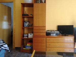 1 dormitorio con tocador de madera y TV. en Villa Rosa, en San Pedro del Pinatar