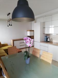 a kitchen with a green table with a vase of flowers on it at Sanshiro apartment in Gdańsk
