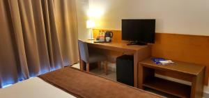 a hotel room with a desk with a television at Ohtels Campo De Gibraltar in La Línea de la Concepción