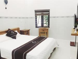um quarto com uma cama branca e uma janela em Hoa Trang Hotel em Tuy An