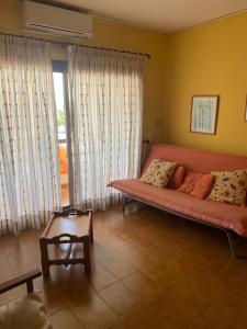 un soggiorno con divano rosso e tavolo di Isla Blanca II 3 ET 249 PL a Es Pujols