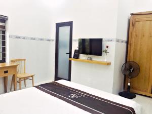 um quarto com uma cama e uma televisão na parede em Hoa Trang Hotel em Tuy An