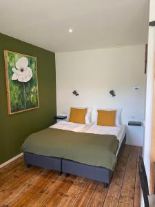 1 dormitorio con 1 cama con pared verde en Studio appartement 1nul9, en Renesse