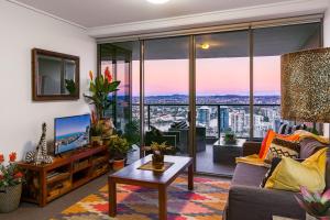 a living room with a couch and a table at African Escape on Level 38 - Balcony with Views in Brisbane