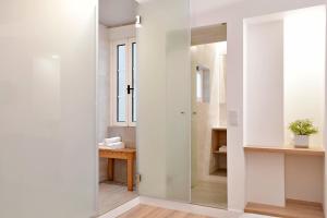 a bathroom with a glass door leading into a room at Residencial Fortunato in Ericeira
