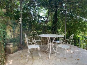 a table and chairs sitting under an umbrella at La Maison Carrée - Villa de charme - Clim & Piscine chauffée in Les Eyzies-de-Tayac