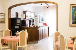 a dining room with a table and chairs and a counter at Hotel Roma in Pisa