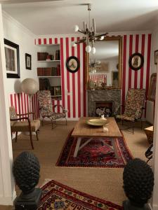 a living room with red and white striped walls at La Maison Carrée - Villa de charme - Clim & Piscine chauffée in Les Eyzies-de-Tayac