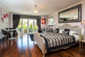 a bedroom with a bed with a mirror and a desk at Windermere Suites in Windermere