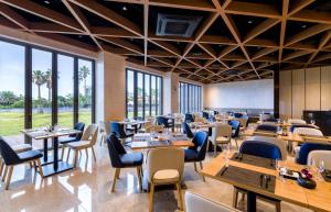 a restaurant with tables and chairs and large windows at The Grand Sumorum in Seogwipo