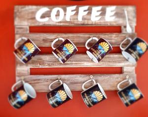 a coffee sign with a bunch of stained glass earrings at Pousada Solar dos Cavaleiros Mendes in Macaé