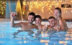un gruppo di persone in piscina che bevono vino di Le Rose Suite Hotel a Rimini