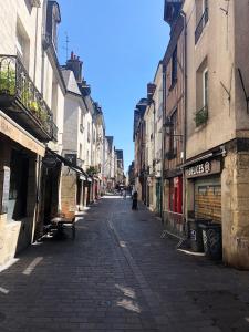 an empty street in a city with buildings at Logement dans le Vieux Tours in Tours