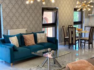 a living room with a blue couch and a table at Rezydencja Wintera Great Apartment in Gdańsk