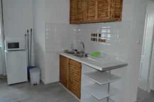 a kitchen with a sink and a refrigerator at Fészek Apartmanház in Tapolca