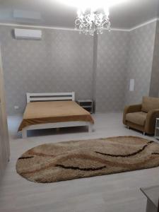 ein Wohnzimmer mit einem Bett und einem Kronleuchter in der Unterkunft Квартира у моря - apartment by the sea - Odessa in Odessa